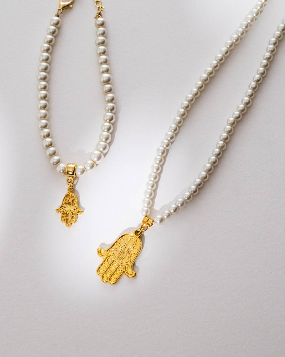 Elegant Hamsa charm pieces with genuine pearl beads by IottiGleam; unique artisanal design for a chic and protected everyday look.