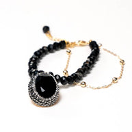 Handcrafted Eos bracelet featuring a strand of black beads paired with a gold-plated chain and a centered black zirconia pendant - Anima Collection by iottigleam