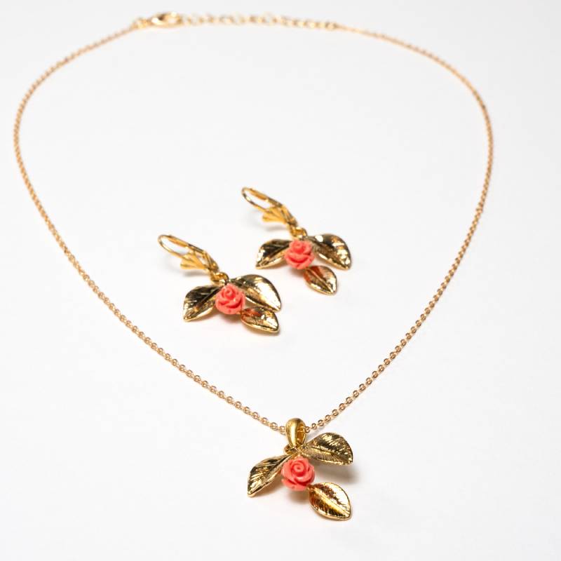 1. The Recommended Alt Text
Handcrafted Frosya accessory set featuring a gold-plated necklace with a petals-shaped pendant and matching earrings with pink flower ornaments - Anima Collection by iottigleam