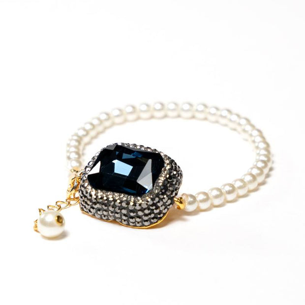 Handcrafted Mara bracelet featuring luminous white glass pearls with a centered, faceted navy blue zirconia stone - Anima Collection by iottigleam